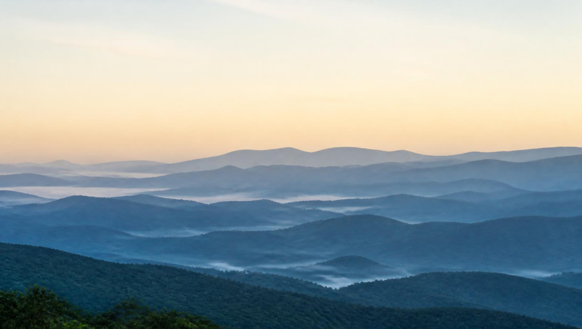Layered Blue Ridge Mountain ridgelines at dawn with mist in the valleys